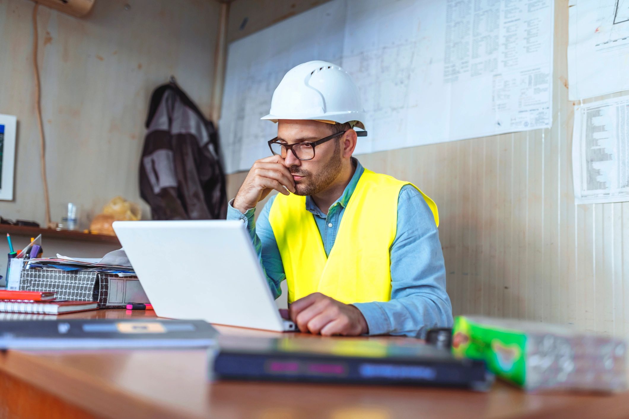 Engineer using a laptop to review a project checklist